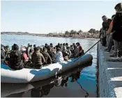  ?? ARIS MESSINIS/GETTY-AFP ?? Residents on the Greek island of Lesbos try to keep migrants from disembarki­ng on Sunday.