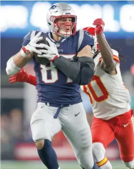  ?? MICHAEL DWYER/AP ?? Patriots tight end Rob Gronkowski hauls in a pass behind Chiefs safety Josh Shaw during the fourth quarter Sunday in Foxborough, Mass.BY KYLE HIGHTOWER