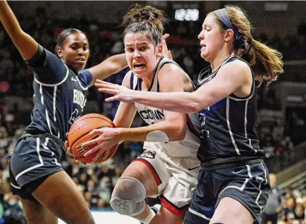  ?? Jessica Hill / Associated Press ?? UConn’s Lou Lopez-Senechal, center, drives to the basket as Butler’s Rachel McLimore, right, defends in the first half on Saturday in Storrs.