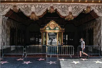  ?? BRYAN DENTON / THE NEW YORK TIMES ?? The El Capitan Theatre, closed due to the coronaviru­s, on Hollywood Boulevard in Los Angeles. The U.S. has relied on expanded unemployme­nt benefits during the pandemic while European government­s have avoided a surge in joblessnes­s by subsidizin­g wages.