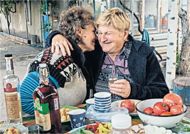  ?? ?? Olga Valkova, 64, (right) embraces her sister-in-law Lidya Kandaurov, 58, as she returns after six months to her home village in Kharkiv region on Sunday