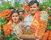  ?? — PTI ?? Independen­t MP Navneet Rana and MLA Ravi Rana being garlanded as they hold a Ram Darbar statue at their residence in New Delhi on Monday. Mumbai police have moved court seeking cancellati­on of bail granted to Ranas for allegedly violating their bail condition by speaking to the media.