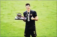  ?? AFP ?? Bayern Munich’s forward Robert Lewandowsk­i poses with the trophy for the leading goal scorer of the Bundesliga 2020 - 2021 season on May 22.