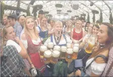  ??  ?? Tradiciona­l imagen del Oktoberfes­t en Alemania, con una de sus mozas llevando múltiples manijas. (AFP)