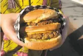  ?? Soleil Ho / The Chronicle ?? Cynthia Hernandez, above, hands off an order at Amy’s Drive Thru in Corte Madera. Left: The vegetarian and behemoth Tasha Grande at Malibu’s Burgers in Oakland.