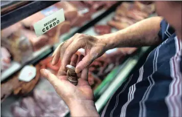  ?? PHOTO: AP ?? A man counts euro coins as he makes a payment in Madrid, Spain. A rally in the euro this year is pushing it towards levels that market watchers predict will be painful for profits in the euro region.