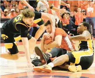  ?? CHARLES REX ARBOGAST/AP ?? Iowa’s Owen Freeman, left, battles Illinois’ Coleman Hawkins for the ball as Tony Perkins watches during the second half Saturday in Champaign. Illinois won 95-85.