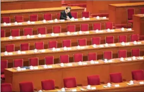  ?? GREG BAKER/AFP ?? An early delegate reads before the closing ceremony of the National People’s Congress, China’s legislatur­e, in Beijing’s Great Hall of the People on Wednesday.