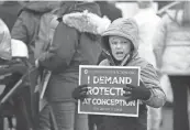  ?? THE CAPITAL-JOURNAL, FILE ?? A young abortion rights opponent holds a sign during the March for Life rally in Topeka, Kansas, in January.