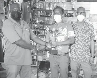  ?? ?? Rugby Manager George David, collects one of the trophies from Victor Sunich of Trophy Stall (Canada) in the presence of Ramesh Sunich at the South Road location.