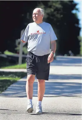  ?? ANGELA PETERSON / MILWAUKEE JOURNAL SENTINEL ?? Tom Krueger walks near his Brown Deer home earlier this month. Krueger has been walking for years, picking up the pace when he retired from his teaching job in 1994. He logs his miles, now exceeding 36,000, in a notebook and on a world globe.