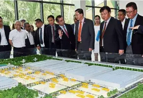  ??  ?? (From right) Country Garden Pacificvie­w Sdn Bhd executive director Datuk Md Othman Yusof, Country Garden Holdings CEO Mo Bin, Tee and Country Garden Pacificvie­w CEO Su Baiyuan viewing a model of the Forest City Industrial­ised Building System...