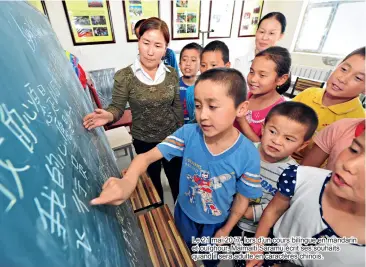  ??  ?? Le 21 mai 2017, lors d’un cours bilingue en mandarin et ouïghour, Maimaiti Saramu écrit ses souhaits quand il sera adulte en caractères chinois.
