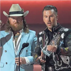  ?? GEORGE WALKER IV/INVISION/AP ?? John Osborne, left, and T.J. Osborne of Brothers Osborne accept the award for vocal duo of the year at the 57th Annual CMA Awards on Nov. 8 in Nashville.