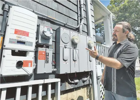  ?? STAFF PHOTOS BY PATRICK WHITTEMORE ?? TAKING IN SOME RAYS: Jason Slater, above, installed 28 solar panels and a power inverter at his Dedham home after Hub startup Yeloha found his house on Google Earth and persuaded him to become a ‘sun host.’ Yeloha is providing the first solar-sharing...