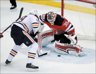  ?? AP PHOTO JULIO CORTEZ ?? New Jersey Devils goalie Cory Schneider (35) deflects a shot by Edmonton Oilers center Leon Draisaitl (29), of Germany, during overtime of an NHL hockey game, Thursday in Newark, N.J. The Oilers won 3-2.