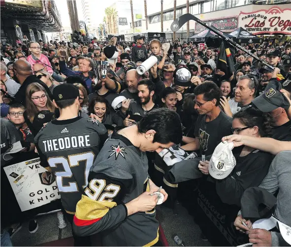  ?? — GETTY IMAGES. ?? Shea Theodore and Tomas Nosek of the Vegas Golden Knights sign autographs for fans as they walk the red carpet at the Vegas Golden Knights Fan Fest at the Fremont Street Experience Sunday in Las Vegas, which packed Freemont Street in the Nevada city.