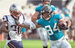  ??  ?? Jaguars wide receiver Keelan Cole stiff-arms Patriots cornerback Jason McCourty on Sunday in Jacksonvil­le, Fla. STEPHEN B. MORTON/AP