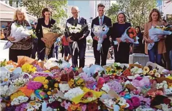  ?? AFP PIC ?? Australian Prime Minister Anthony Albanese (third from left) with New South Wales Premier Chris Minns (third from right) and other officials as they prepare to leave flowers outside the Westfield Bondi Junction mall in Sydney on Sunday.