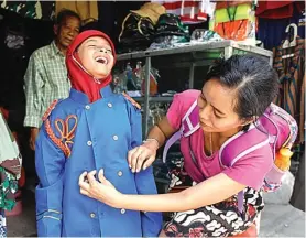  ?? DIPTA WAHYU/JAWA POS ?? SAMBUT 10 NOVEMBER: Siswa SDN Wadung Asri, Waru, Sidoarjo, mendapat penjelasan mengenai koleksi Museum Sepuluh Nopember kemarin. Foto kanan, Chelsea Aulia Kristianto, siswa kelas I SDN 7 Simomulyo, dengan dibantu ibunya, Suci Mayandani, mencoba kostum karnaval di Pasar Joyoboyo.