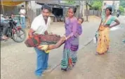  ?? HT PHOTO ?? Lakshman Oraon and his wife carrying his brother Rajendra Oraon’s body as they were unable to pay for a hearse vehicle in Chatra, Jharkhand, on Sunday.