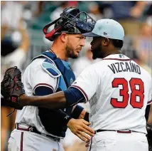  ?? CURTIS COMPTON/CCOMPTON@AJC.COM ?? Braves catcher Tyler Flowers and closer Arodys Vizcaino celebrate a 4-1 victory over the Padres on Sunday in Atlanta. It was the 15th save of the season for Vizcaino.