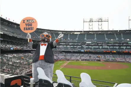  ?? Ezra Shaw / Getty Images 2020 ?? Giants mascot Lou Seal, in the right field arcade at Oracle Park, waves to fans outside during a July game against San Diego.