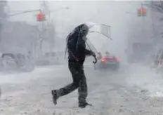  ?? Reuters ?? A man walks with an umbrella through snowfall in the Harlem section of upper Manhattan in New York, on Thursday.