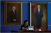  ?? ?? Cal State San Bernardino student Jason Trang goes without a mask Thursday while studying for finals under portraits of CSUSB past President Albert K. Karnig and present President Tomás D. Morales in the campus library.