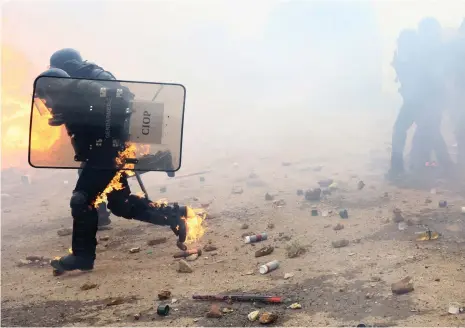  ?? Reuters ?? Gendarmeri­e officers run after being attacked with improvised explosives during the demonstrat­ion