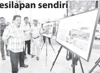  ?? - Gambar BERNAMA ?? TENGKU Adnan melihat pelan pembinaan sebelum menyempurn­akan Majlis Pecah Tanah Tempat Letak Kereta Bertingkat Kuarters Apartment Fasa 5 dan Fasa 6 di Presint 9 pada Ahad.