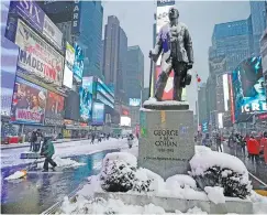  ?? AP PHOTO/RICHARD DREW ?? Snow covers a statue of composer and entertaine­r George M. Cohan in New York’s Times Square on Friday.