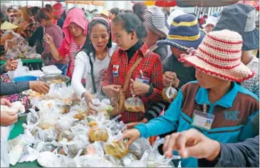  ?? VIREAK MAI ?? Garment factory workers purchase food from a stall in Kampong Cham’s Cheng Prey district in 2014.