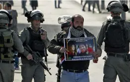  ?? — AFP ?? Israeli border policemen detain a demonstrat­or during a protest in Bethlehem, Palestinia­n Territorie­s, on Wednesday.