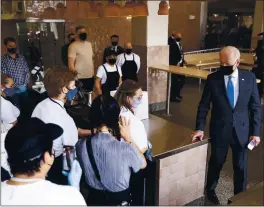  ?? EVAN VUCCI — THE ASSOCIATED PRESS ?? President Joe Biden talks with staff during a visit to Taqueria Las Gemelas restaurant in Washington, D.C., on Wednesday.