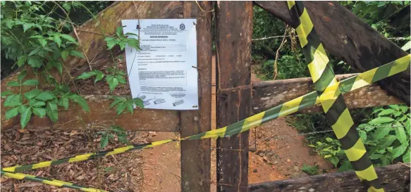  ?? PHOTOS BY MARK HOFFMAN, MILWAUKEE JOURNAL SENTINEL ?? A notice posted in the village of Córrego da Luz, Brazil, warns visitors that a trail leading to a waterfall is closed because mosquitoes carrying the yellow fever virus have been detected.