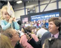  ?? The Washington Post/Getty Images ?? FOX NEWS has capitalize­d on the surprise Republican victory of Trump by adding conservati­ve commentato­r Tucker Carlson, right, shown covering a Bernie Sanders rally in February.