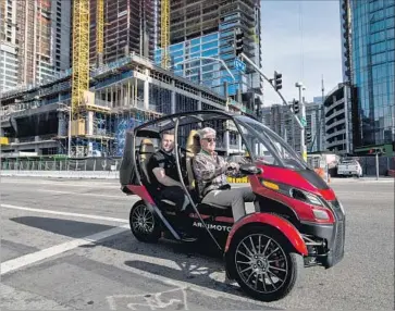  ?? Kent Nishimura Los Angeles Times ?? THE ARCIMOTO is test-driven at the auto show. Electric power is sent to the two front wheels by twin motors. The base model will cost about $11,500 and have a top speed of 80 mph and a range of about 70 miles.