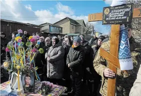  ?? THIBAULT CAMUS THE ASSOCIATED PRESS ?? Mourners gather next to the body of Vladyslav Bondarenko during his funeral in Kozyntsi, near Kyiv, Ukraine, on Monday. Bondarenko, a paratroope­r of airmobile brigade, died near Bakhmut on Feb. 26.