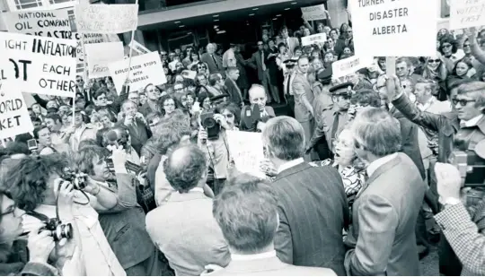  ??  ?? Protestors besiege Prime Minister Pierre Trudeau (balding, with his back to the camera) in Calgary, June 1974. The Trudeau government’s energy policies were hugely unpopular with Albertans and critics said this contribute­d to western alienation.