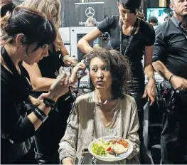  ??  ?? Hair and makeup assistants groom a model backstage at a recent Johannesbu­rg fashion week.