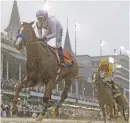  ?? MORRY GASH/THE ASSOCIATED PRESS ?? Mike Smith rides Justify through the slop to win the Kentucky Derby by 2½ lengths Saturday at Churchill Downs.
