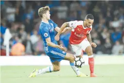  ??  ?? Theo Walcott, jugador de Arsenal, a la derecha, lucha por la posesión de un balón con Marcos Alonso, del Chelsea.