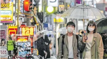  ?? FOTO: KYODO/DPA ?? Passanten in der japanische­n Hauptstadt Tokio tragen Masken zum Schutz vor dem neuartigen Coronaviru­s: In Asien ist die Nutzung der Masken unumstritt­en, in Europa dagegen nicht.