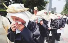  ?? AP ?? Family members of late war veterans weep during a rally to demand payment of family allowance during a ceremony to mark the 68th anniversar­y of the Korean War in Seoul yesterday.