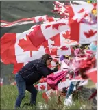  ?? The Canadian Press ?? A woman places a memorial near Kamloops airport on May 21.