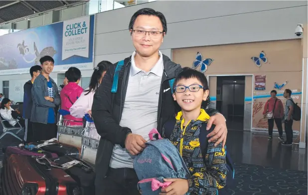  ?? Picture: PETER CARRUTHERS ?? PERFECT ESCAPE: Yuem Mang with son Daniel, 8, arriving in Cairns yesterday after an ordeal boarding a flight departing Hong Kong.