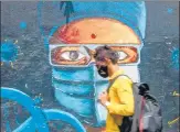  ?? SATISH BATE/HT PHOTO ?? A man wearing a mask walks past a graffiti depicting a Covid warrior amid a surge in infections in Mumbai.