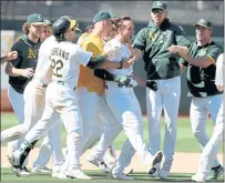  ?? ANDA CHU — STAFF PHOTOGRAPH­ER ?? Oakland teammates mob Matt Olson, center, after his two-run walk-off double in the 10th inning sealed a 5-4 win over San Diego.