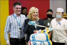  ?? Susan Walsh/Associated Press ?? First lady Jill Biden cuts a cake with George Ciolache, the cakemaker, as she meets with U.S. troops during a visit to the Mihail Kogalnicea­nu Air Base in Romania.